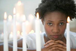 african american woman praying candles